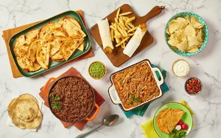 A spread of quesadillas, shredded meats, enchiladas, handhelds, sides and dips